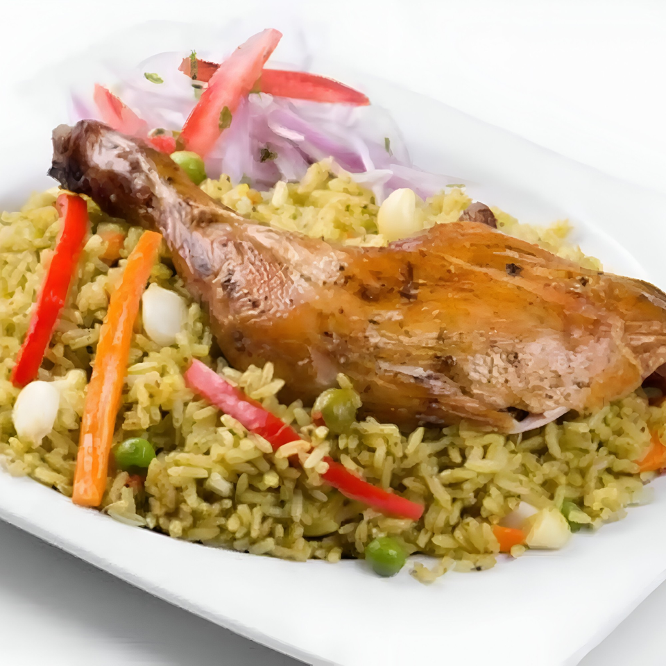 Peruvian Arroz con Pollo, a chicken drumstick on green rice with vegetables and red onion.